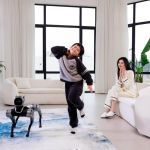 Magicdog EDU Roboterhund beobachtet tanzenden Jungen, Frau applaudiert im Wohnzimmer