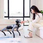 Magicdog EDU Roboterhund im Wohnzimmer bei der Interaktion mit einer Frau in entspannter Umgebung